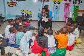Dr. Annette Akinsete reads with a group of children supported by SCFN