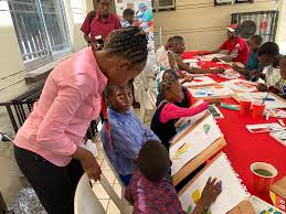 An SCFN counsellor works with children at an arts table