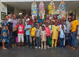 SCFN staff, volunteers and children gather for a group photo at a community programme